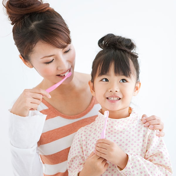Need routine cleanings A woman and a little girl brushing their teeth