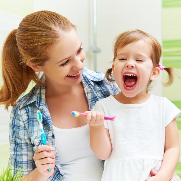 Nurturing Preventive Dentistry Habits in Kids at Home A girl with a mother clean teeth
