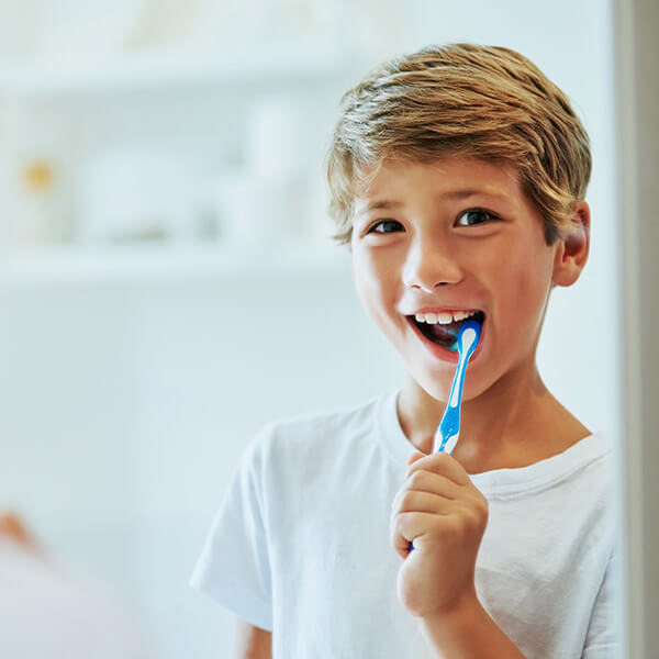 Early Detection Through a Comprehensive Perspective A boy brushing his teeth and smiling
