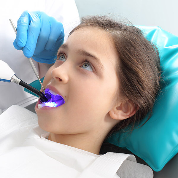 Steps to Ease a Child's Toothache Discomfort A treatment procedure for a little girl in a dental chair