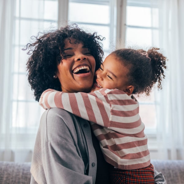 Positive, Stress-Free Visits A girl and her mother hugging each other while smiling